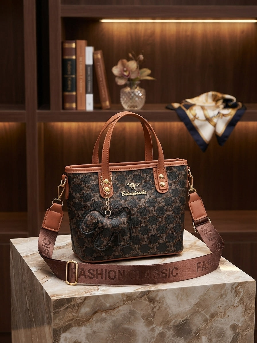 Structured monogram tote bag with tan shoulder straps and hanging animal charm